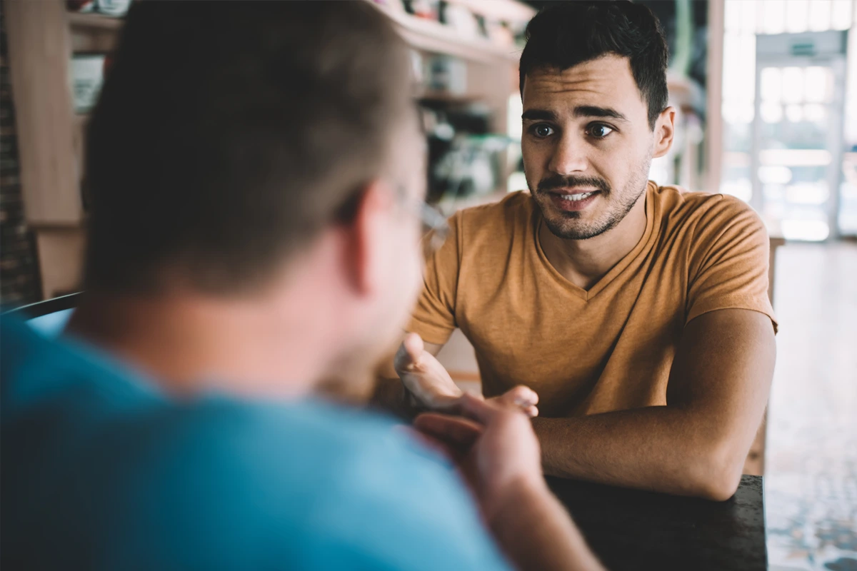 What-To-Expect-At-Changes-Healing-Center A group therapy session with three men seated in a circle, engaging in a supportive conversation in a bright room.