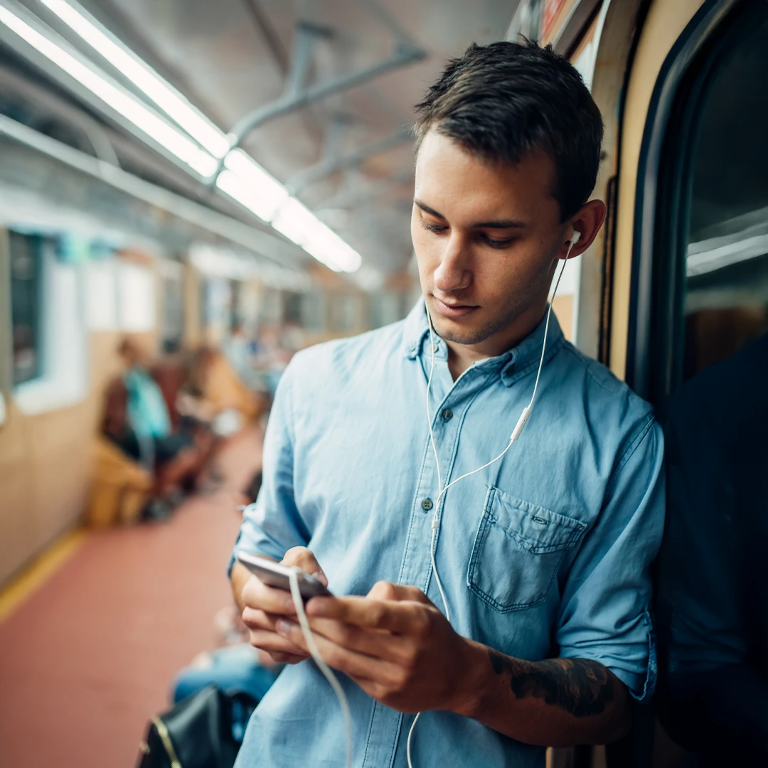 Substance-Use-Treatment-Covered-by-Insurance-At-Changes-Healing-Center Man on public transit viewing his phone—using insurance for substance use treatment.